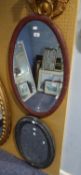 TWO PAINTED OVAL WALL MIRRORS, one in red with bevel edged plate, 29? x 19 ½?, the other grey, 23? x