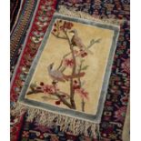 CHINESE PART SILK SMALL PICTORIAL RUG depicting two small garden birds on a flowering bough, pale