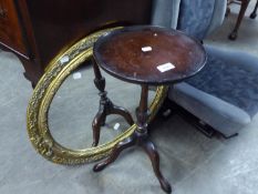 AN OVAL GILT FRAMED WALL MIRROR AND A REPRODUCTION TRIPOD WINE TABLE (2)