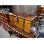 AN ORIENTAL STAINED PINE AND METAL STRAPWORK STORAGE/BLANKET BOX WITH END HANDLES