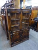 A 'RACKSTRAW' OPEN BOOKCASE, THE UPPER SECTION HAVING TWO GLASS PANEL DOORS, OVER TWO PANEL DOORS