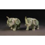 PAIR OF CHINESE CARVED SPECKLED GREY/GREEN MODELS OF ELEPHANTS, with trunks raised, 2 1/4in (5.75cm)