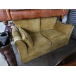 A LARGE TWO SEATER SETTEE UPHOLSTERED IN GOLD FABRIC, HAVING LOOSE CUSHIONS