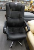 AN EXECUTIVE?S BLACK UPHOLSTERED REVOLVING OFFICE ARMCHAIR, ON BRIGHT METAL FIVE SPUR BASE WITH