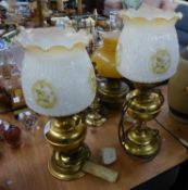 A PAIR OF BRASS OIL TABLE LAMPS WITH WHITE OPAQUE MOULDED GLASS SHADES WITH FRILL TOP AND A COPPER