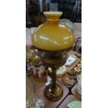 A BRONZE FINISH METAL CORINTHIAN COLUMN TABLE OIL LAMP, WITH YELLOW GLASS SHADE AND GLASS FUNNEL