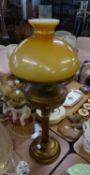 A BRONZE FINISH METAL CORINTHIAN COLUMN TABLE OIL LAMP, WITH YELLOW GLASS SHADE AND GLASS FUNNEL