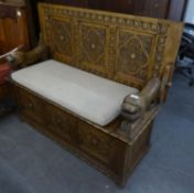 AN INTER-WAR YEARS CARVED OAK MONKS BENCH, WITH LIFT-UP SEAT AND CARVED LION ARMS