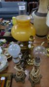 A BRASS OIL TABLE LAMP WITH YELLOW GLASS SHADE AND GLASS FUNNEL, FITTED FOR ELECTRIC LIGHT
