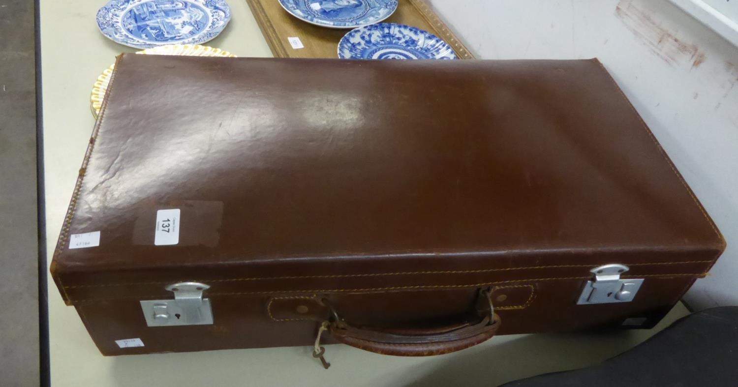 AN OLD LEATHER SUITCASE