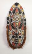 NEW GUINEA LARGE CARVED AND PAINTED WOOD WALL SHIELD, inlaid with small cowrie shells, the lower