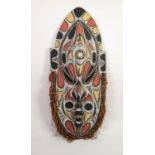NEW GUINEA LARGE CARVED AND PAINTED WOOD WALL SHIELD, inlaid with small cowrie shells, the lower