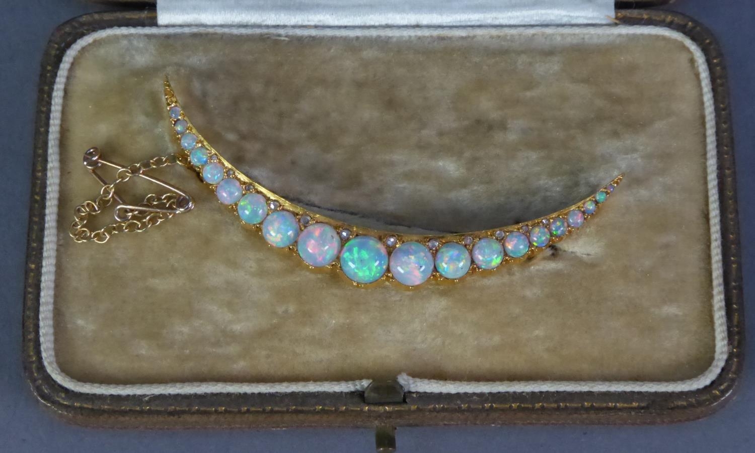 EARLY 20th CENTURY, UNMARKED AND UNTESTED HIGH CARAT GOLD CRESCENT-SHAPE BROOCH set with nineteen (