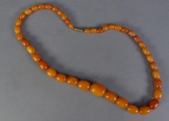 SINGLE STRAND NECKLACE OF GRADUATED OVAL BUTTERSCOTCH AMBER BEADS with metal screw clasp, 20in (