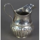 UNMARKED ANTIQUE SILVER MILK JUG, of part fluted and footed baluster form with high scroll handle