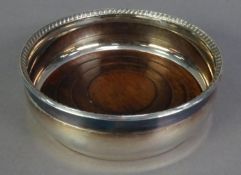 GEORGIAN STYLE SILVER COASTER, cast as one piece with gadrooned inner edge, loose turned wood innner