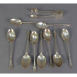 AN INCOMPLETE SET OF NINE EARLY 20TH CENTURY SILVER TEASPOONS AND MATCHING SUGAR TONGS, by