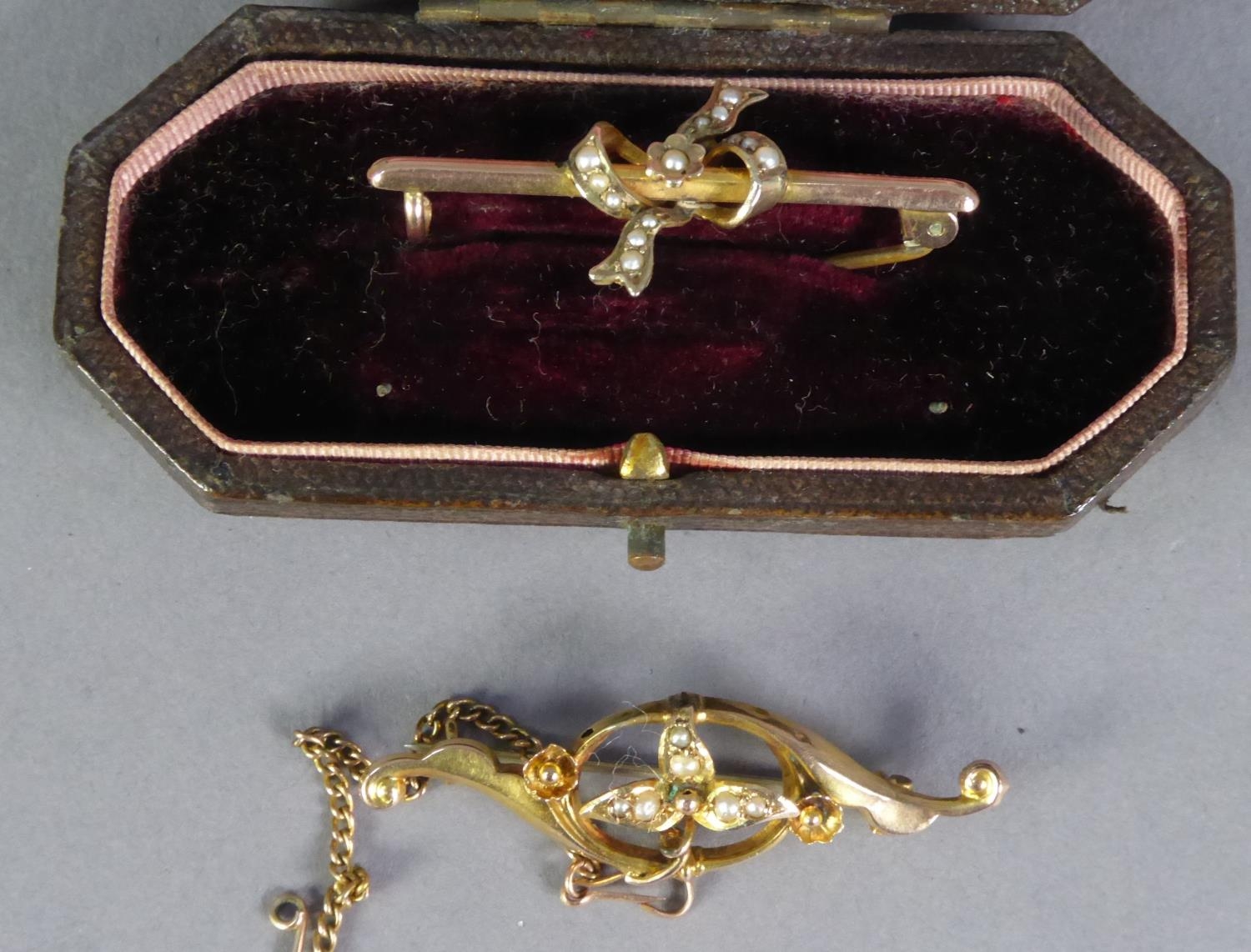 TWO INDISTINCTLY MARKED EDWARDIAN GOLD AND SEED PEARL SET BROOCHES, one with a safety chain, one