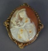 VICTORIAN GOLD COLOUR METAL MOUNTED CARVED SHELL CAMEO brooch of a lady seated giving drinking water