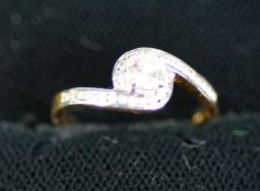 18ct GOLD CROSS-OVER RING SET WITH A SOLITAIRE DIAMOND, approximately .25ct and 28 tiny diamonds