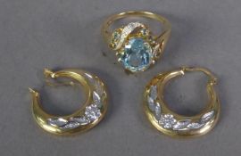 9ct GOLD CROSS-OVER RING set with an oval pale blue zircon, ten small round zircons and six tiny