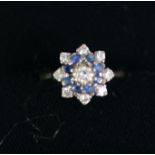 DIAMOND AND SAPPHIRE THREE TIER DAISY CLUSTER RING, with centre diamond over a surround of eight