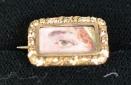 EARLY 19th CENTURY COLOURED METAL TINY GLAZED OBLONG 'LOVERS EYE' BROOCH with chased frame enclosing