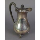 GEORGE V SILVER HOT WATER JUG, of pyriform with black scroll handle and knop and stepped hoof