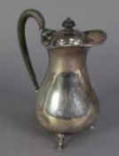 GEORGE V SILVER HOT WATER JUG, of pyriform with black scroll handle and knop and stepped hoof