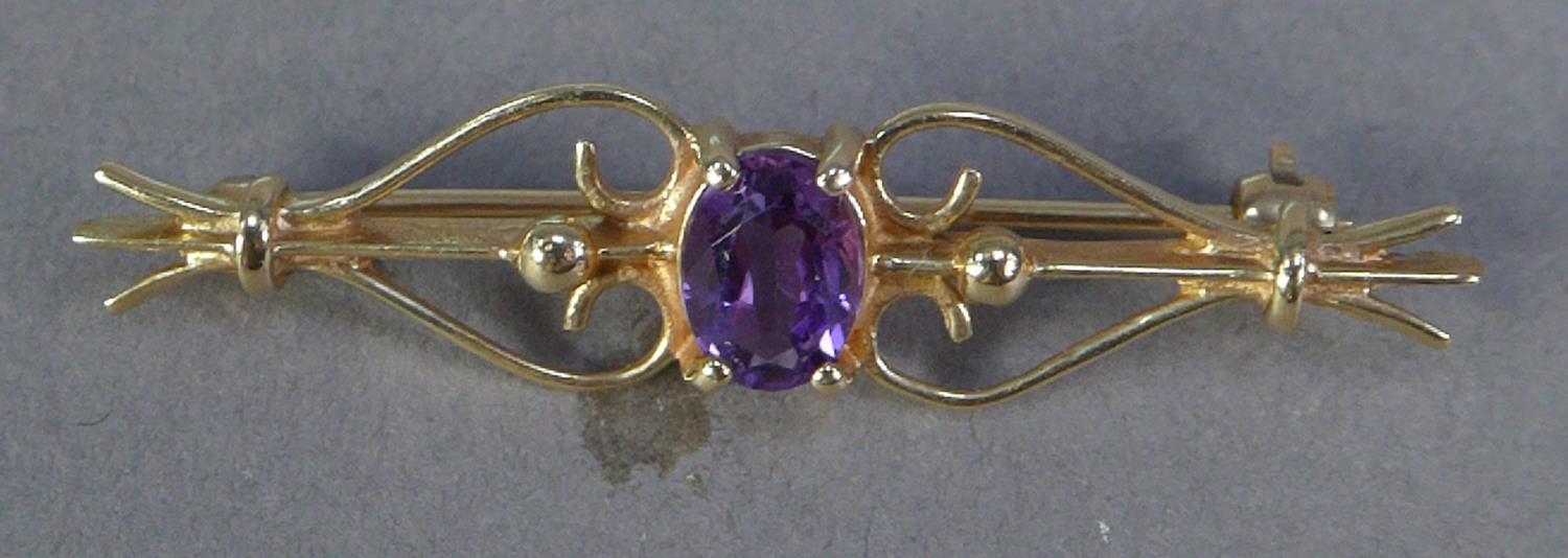 9ct GOLD OPENWORK SCROLL BAR BROOCH, collet set with centre oval amethyst, 2.3gms