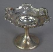 GEORGE V PIERCED AND WEIGHTED SILVER PEDESTAL SMALL SWEET MEAT DISH, slot pierced beneath a scroll