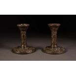 PAIR OF EMBOSSED AND WEIGHTED SILVER DRESSING TABLE CANDLESTICKS, each of typical form, profusely