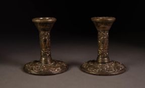 PAIR OF EMBOSSED AND WEIGHTED SILVER DRESSING TABLE CANDLESTICKS, each of typical form, profusely