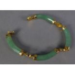 CHINESE GOLD PLATED BRACELET, with four pale green jade links, curbed cylindrical bar links with