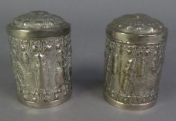 PAIR OF INDIAN EMBOSSED WHITE METAL CYLINDRICAL BOXES AND COVERS, repousse autour with figures and