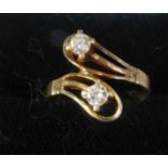 14ct GOLD CROSSOVER RING having double loop pattern top set with two round brilliant cut diamonds,