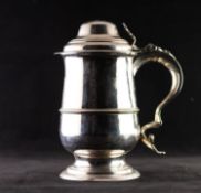 GEORGE II SILVER QUART TANKARD WITH COVER, of footed form with moulded girdle, fancy scroll handle