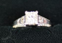 18ct WHITE GOLD RING with a princess cut solitaire diamond in a four claw setting, a princess cut