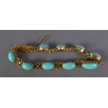 A GOLD COLOURED METAL CHAIN BRACELET, with nine links, each set with a cabochon oval sleeping beauty