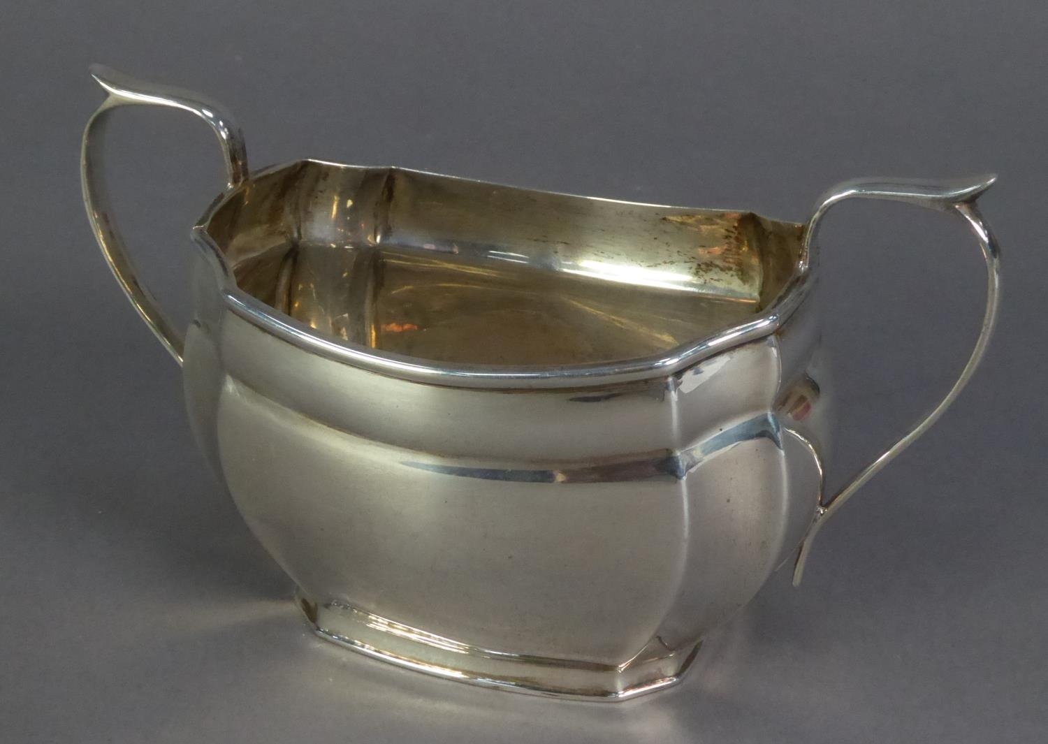 GEORGE VI SILVER TWO HANDLED SUGAR BASIN, of rounded oblong form with concave corners and scroll