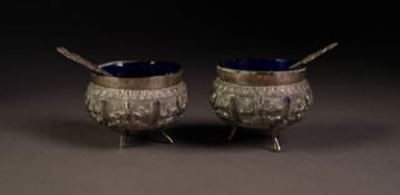 PAIR OF UNMARKED INDIAN EMBOSSED SILVER COLOURED METAL OPEN SALTS, each of circular form with scroll