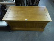 AN OAK BLANKET CHEST WITH FRAMED TWO PANEL FRONT