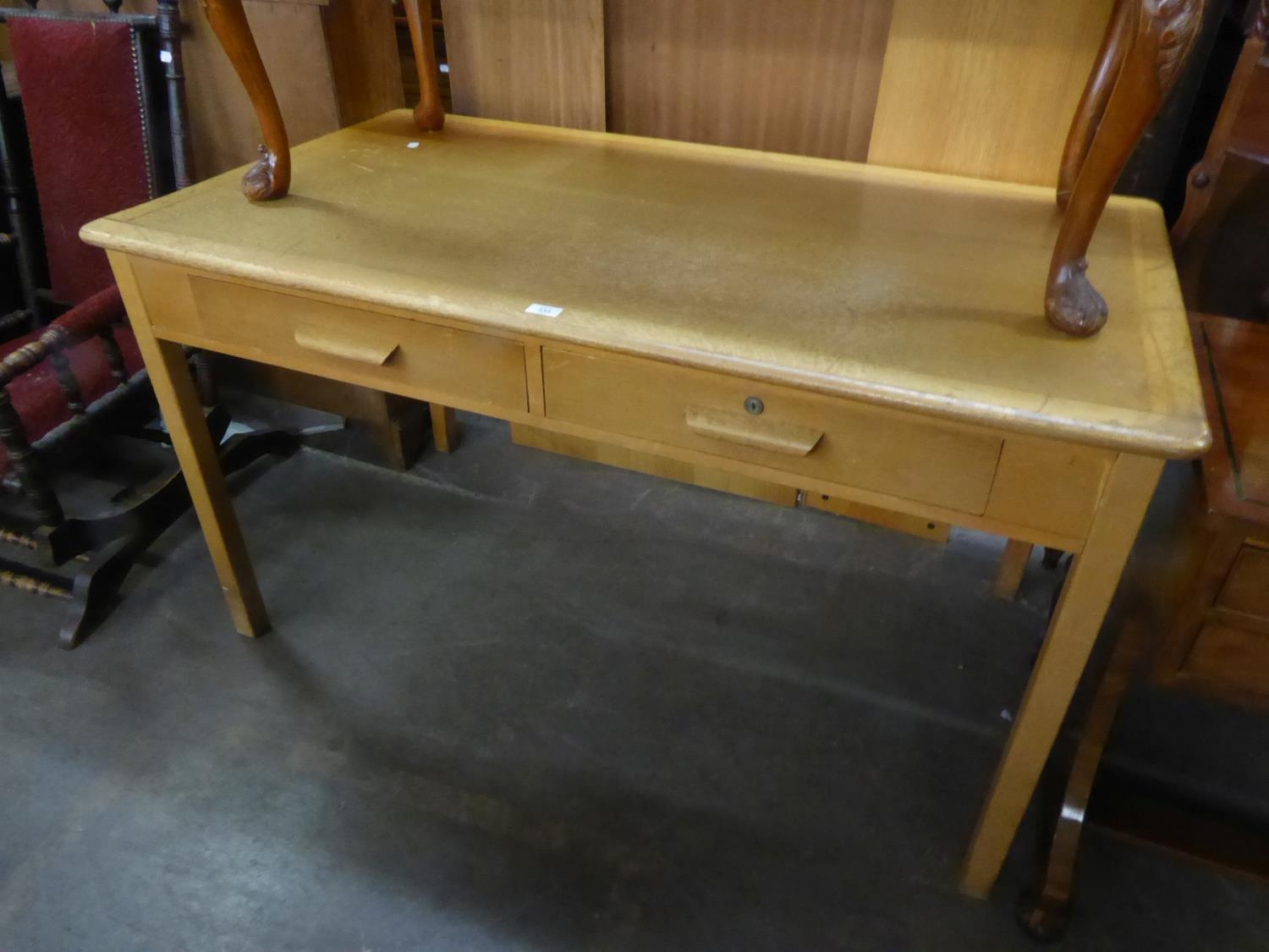 A LIGHT OAK DESK WITH PANEL END SUPPORTS AND A LIGHT OAK OFFICE WRITING TABLE, OBLONG WITH TWO