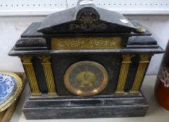 A LARGE BLACK SLATE MANTEL CLOCK, WITH ROMAN NUMERAL DIAL AND DECORATED WITH BRASS COLUMNS