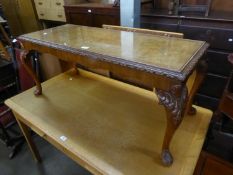 A FIGURED WALNUT OBLONG COFFEE TABLE WITH CARVED BORDER AND ACANTHUS CARVED CABRIOLE SUPPORTS,