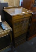 AN OAK TAMBOUR FRONT FILING CABINET WITH DRAWER ENCLOSED