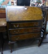 A FIGURED WALNUT BUREAU WITH THREE LONG DRAWERS, ON CABRIOLE SUPPORTS