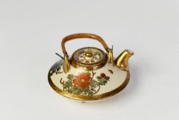 JAPANESE SATSUMA MINIATURE TEA KETTLE AND COVER, of compressed form with woven cane swing handle,