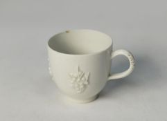 18th CENTURY BOW WHITE CHINA COFFEE CUP, moulded with three groups of prunus blossoms, 2 3/8in (6cm)