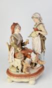 AN EARLY 1900's GERMAN BISQUE PORCELAIN FIGURAL GROUP of a seated cavalier  with serving maid,